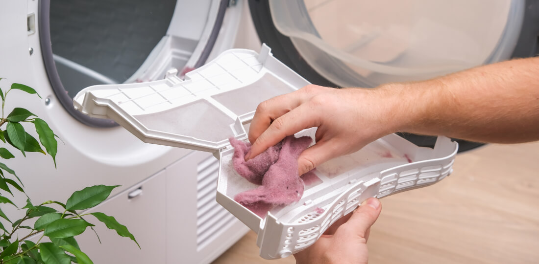 Person's hands removing the lint from a dryer's lint trap