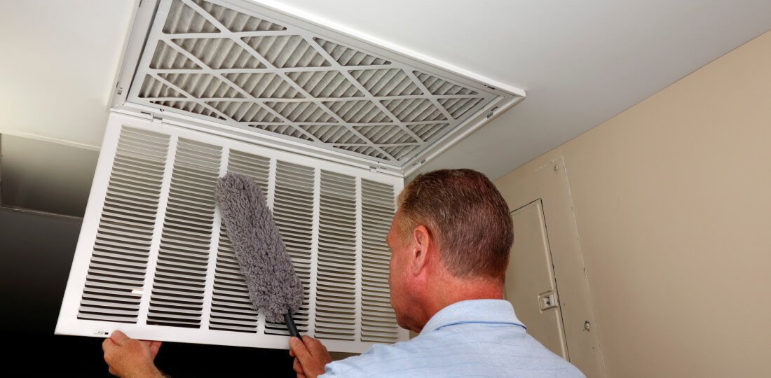 Person cleaning a vent cover